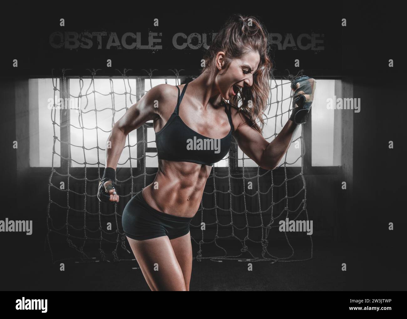 Femme musclée forte fléchissant son biceps après l'entraînement. Le concept de façonnage, de musculation, d'aérobic, d'étirement. Supports mixtes Banque D'Images