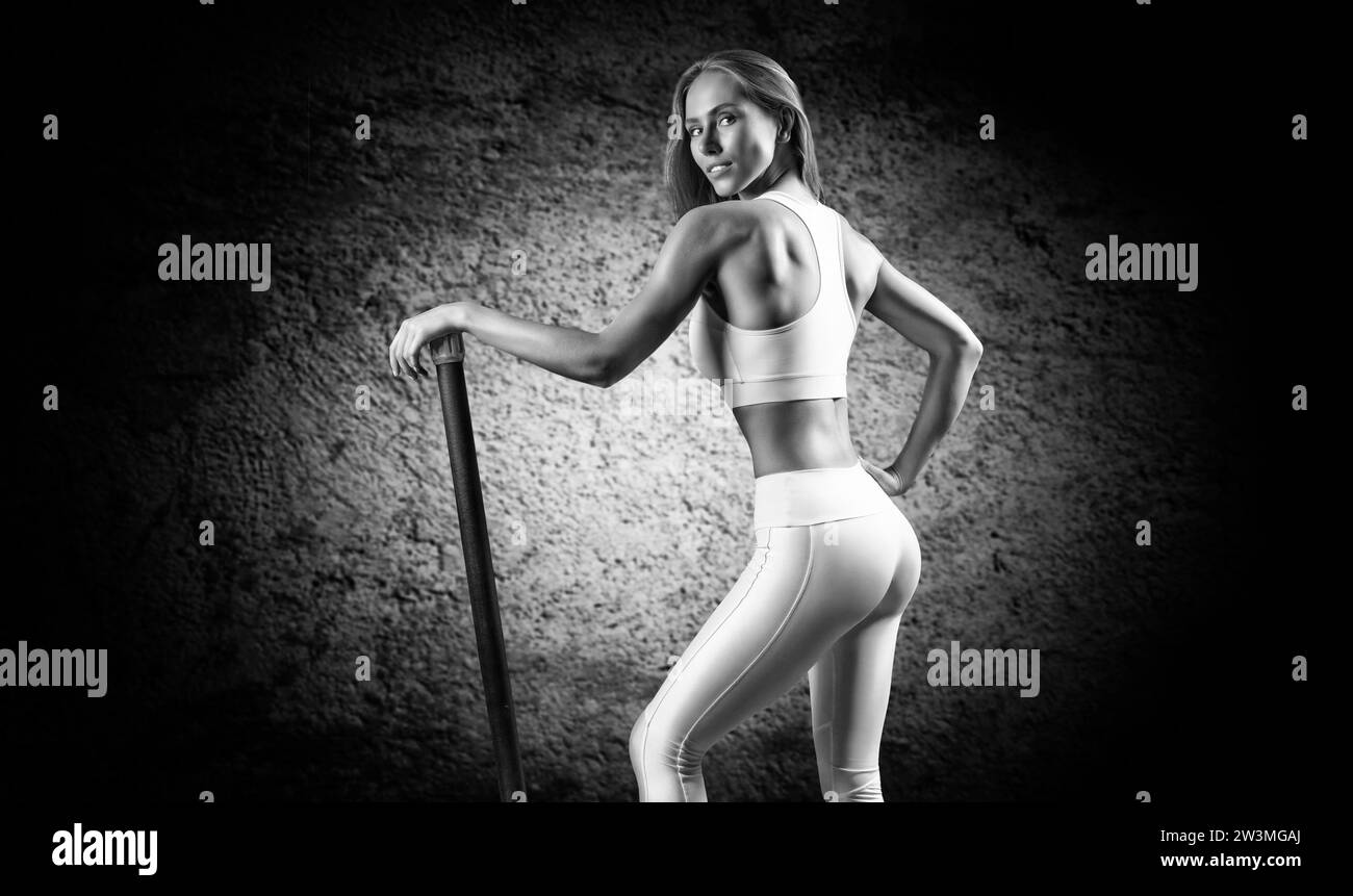 Charmante fille posant avec un bodybar. Le concept de fitness, de musculation et de mode de vie sain. Supports mixtes Banque D'Images
