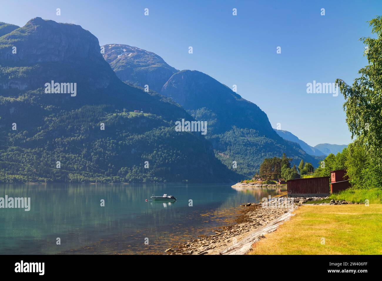 Un bateau à moteur flotte dans les eaux calmes de Barsnesfjorden, près de la municipalité de Sogndal de Krossen Rest Stop, pendant une matinée d'été. Banque D'Images