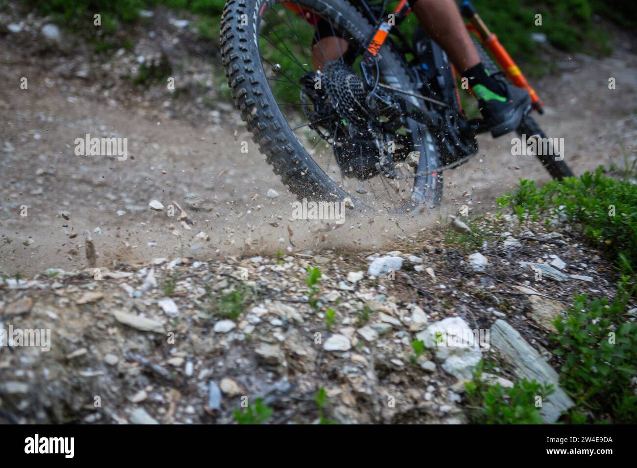 Un pneu de vélo de montagne qui dérive et jette du gravier dans les airs sur le sentier Banque D'Images