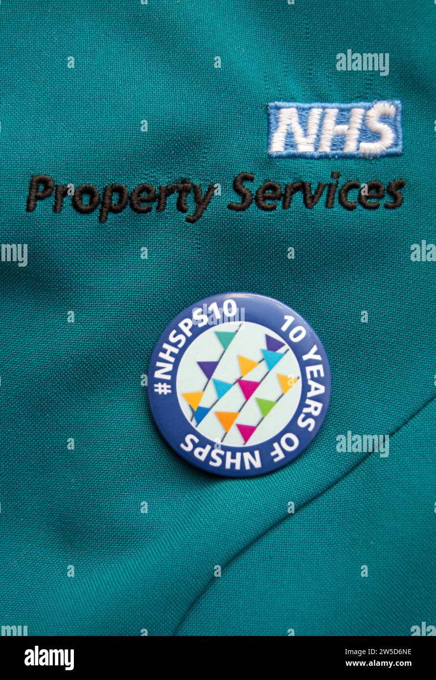 badge de lapel marquant dix ans de service national de santé des services de propriété (nhsps) porté sur une tunique nhsps Banque D'Images