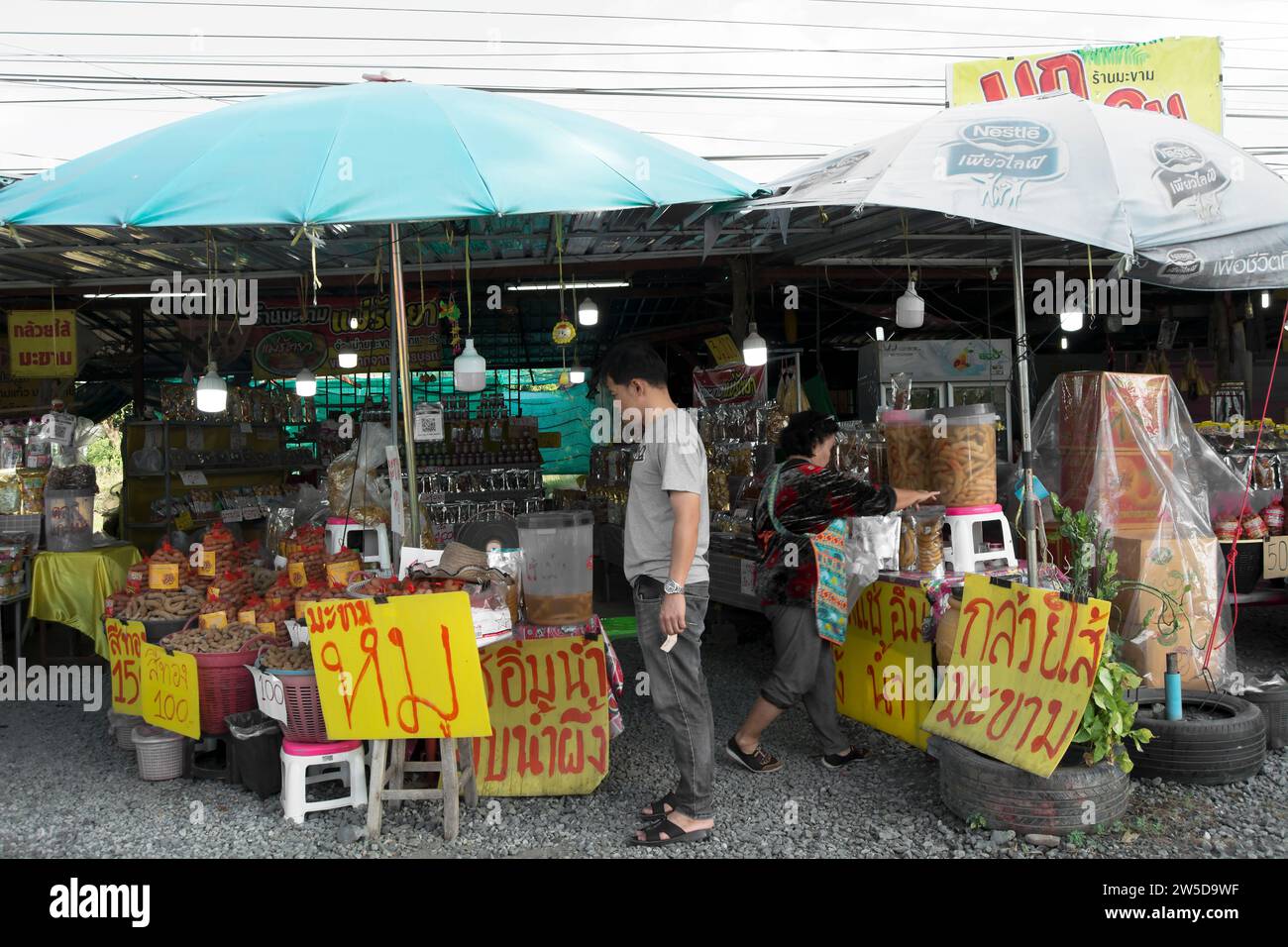 un client inspecte la variété de tamarin en vente sur un stand en bordure de route près de phetchabun, en thaïlande, une région connue pour la production de tamarin Banque D'Images