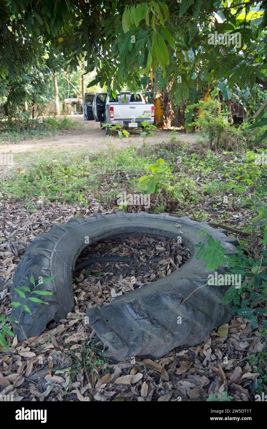 pneu endommagé jeté sur le sol à côté d'une route arrière dans la province de phetchabun, thaïlande Banque D'Images
