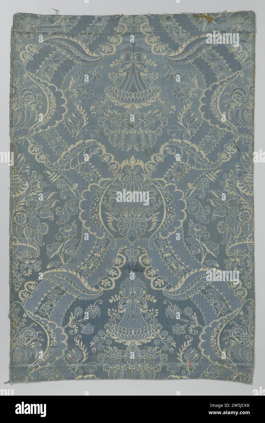 Fragment de tissu de soie de couleur bleue et blanche avec motif de fleurs stylisées et vases et pneus festonnés, feuilles et branches de fleurs ,, c. 1695 - c. 1705 fragment, bleu et blanc avec motif de pneus à enroulement avec vases floraux. Lampas en soie des pays-Bas (matière textile) fragment, bleu et blanc avec motif de pneus à enroulement avec vases floraux. Lampas en soie des pays-Bas (matières textiles) Banque D'Images