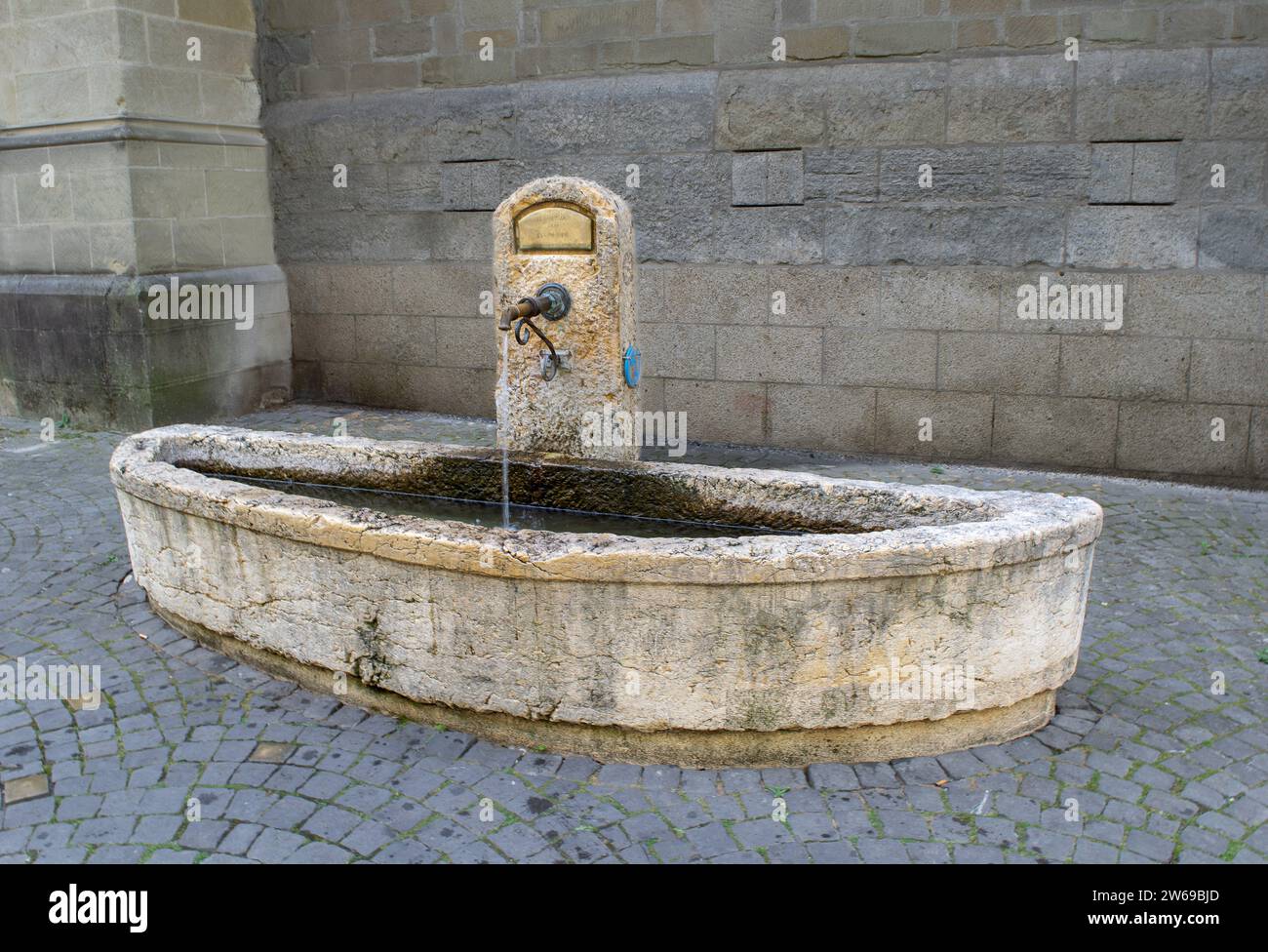 Les passants pieux boivent à l'humble fontaine de St. Église François à Lausanne Suisse Banque D'Images