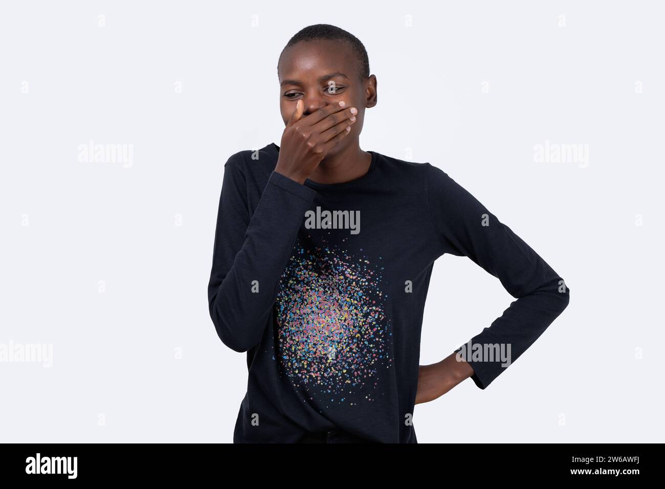 Joyeux modèle afro-américain de mode couvrant la bouche avec la main sur fond blanc Banque D'Images