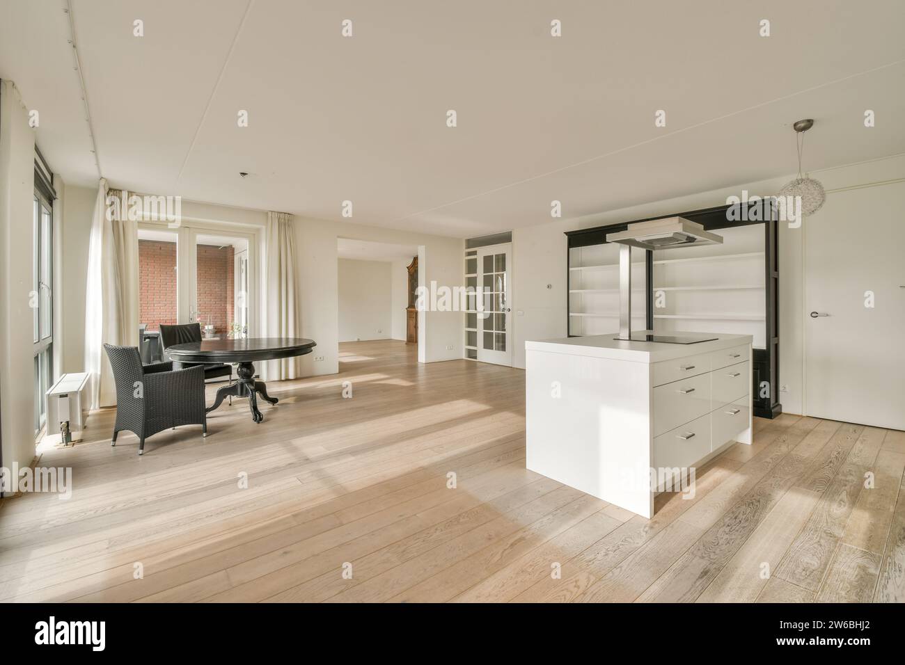 Cuisine moderne avec îlot central, adjacente à un coin repas avec une