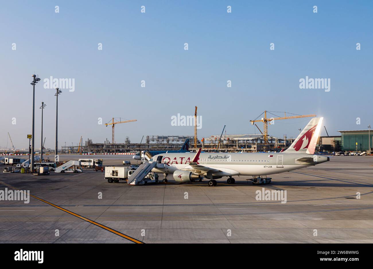 Vue latérale d'un avion Airbus A320-214 de Qatar Airways debout à l'aéroport international Hamad à Doha, Qatar Banque D'Images