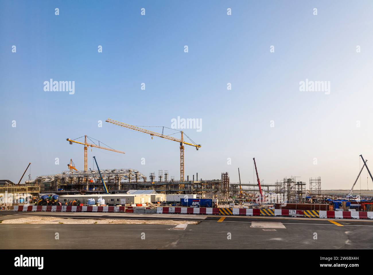 Nouveaux travaux de construction en cours et grues à tour jaunes Liebherr à l'aéroport international Hamad de Doha, Qatar, Moyen-Orient Banque D'Images