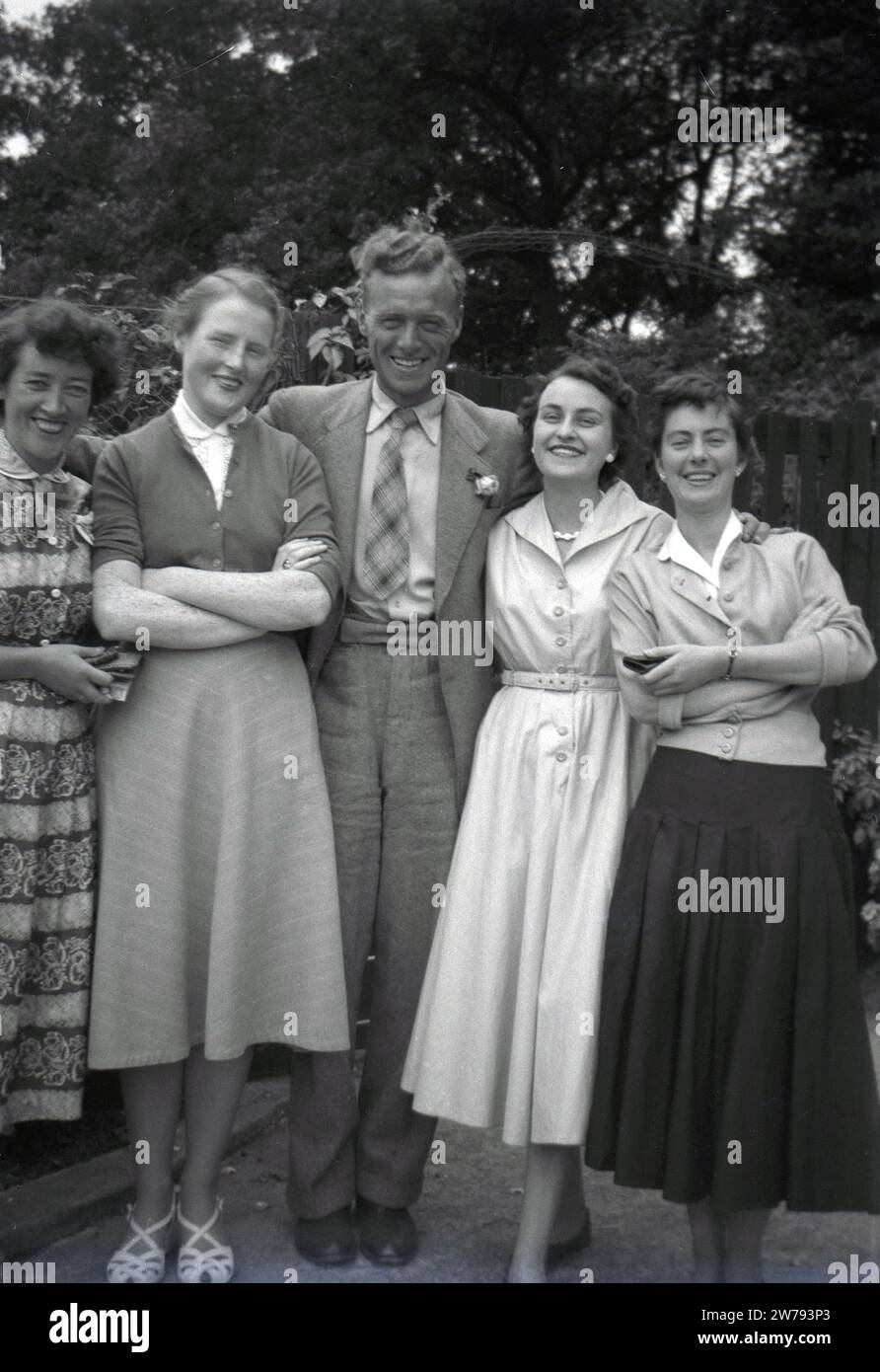 Années 1950, histoire, famille heureuse, une mère et un père se tiennent pour une photo avec leurs filles, Angleterre, Royaume-Uni. Les trois jeunes femmes portent les jupes élégantes et les hauts féminins stylistes de l'époque, Banque D'Images