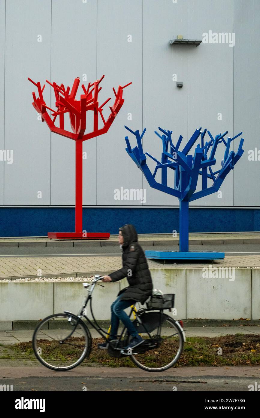 07.11.2023, Allemagne, Brême, Brême - cycliste devant deux arbres en plastique désolés à l'entrée d'un lave-auto. 00A231107D040CAROEX.JPG [MODÈLE REL Banque D'Images