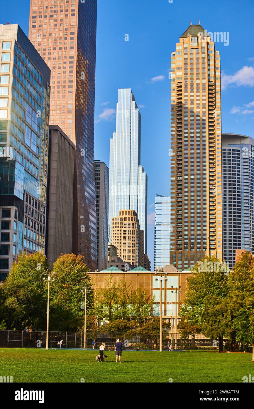 Garez-vous par beau temps dans le centre-ville de Chicago avec des gratte-ciel lumineux et dorés et un ciel bleu Banque D'Images