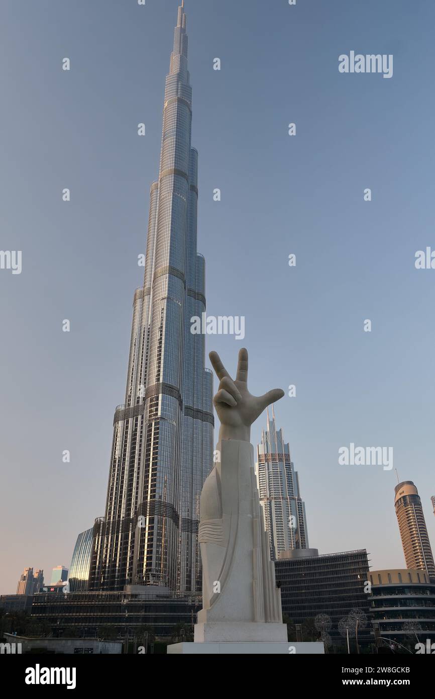 La statue à 3 doigts symbolisant Win Victory Love, et Burj Khalifa dans Burj Park dans le centre-ville de Dubaï, Émirats arabes Unis Banque D'Images