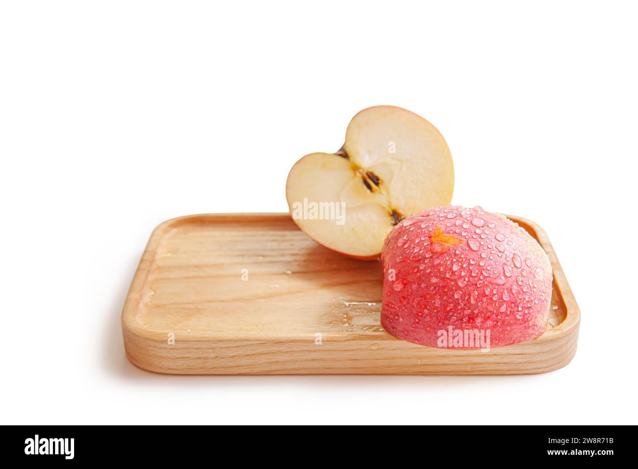 Fruit de pomme a été coupé sur plateau en bois isolé sur fond blanc Banque D'Images