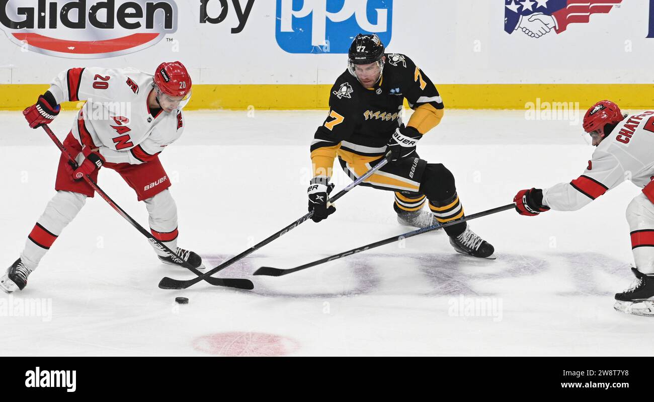 Pittsburgh, États-Unis. 21 décembre 2023. Jeff carter (77), le centre des Penguins de Pittsburgh, affronte le centre des Hurricanes de la Caroline Sebastian Aho (20) et le défenseur des Hurricanes de la Caroline Jalen Chatfield (5) lors de la première période au PPG Paints Arena de Pittsburgh le jeudi 21 décembre 2023. Photo de Archie Carpenter/UPI. Crédit : UPI/Alamy Live News Banque D'Images