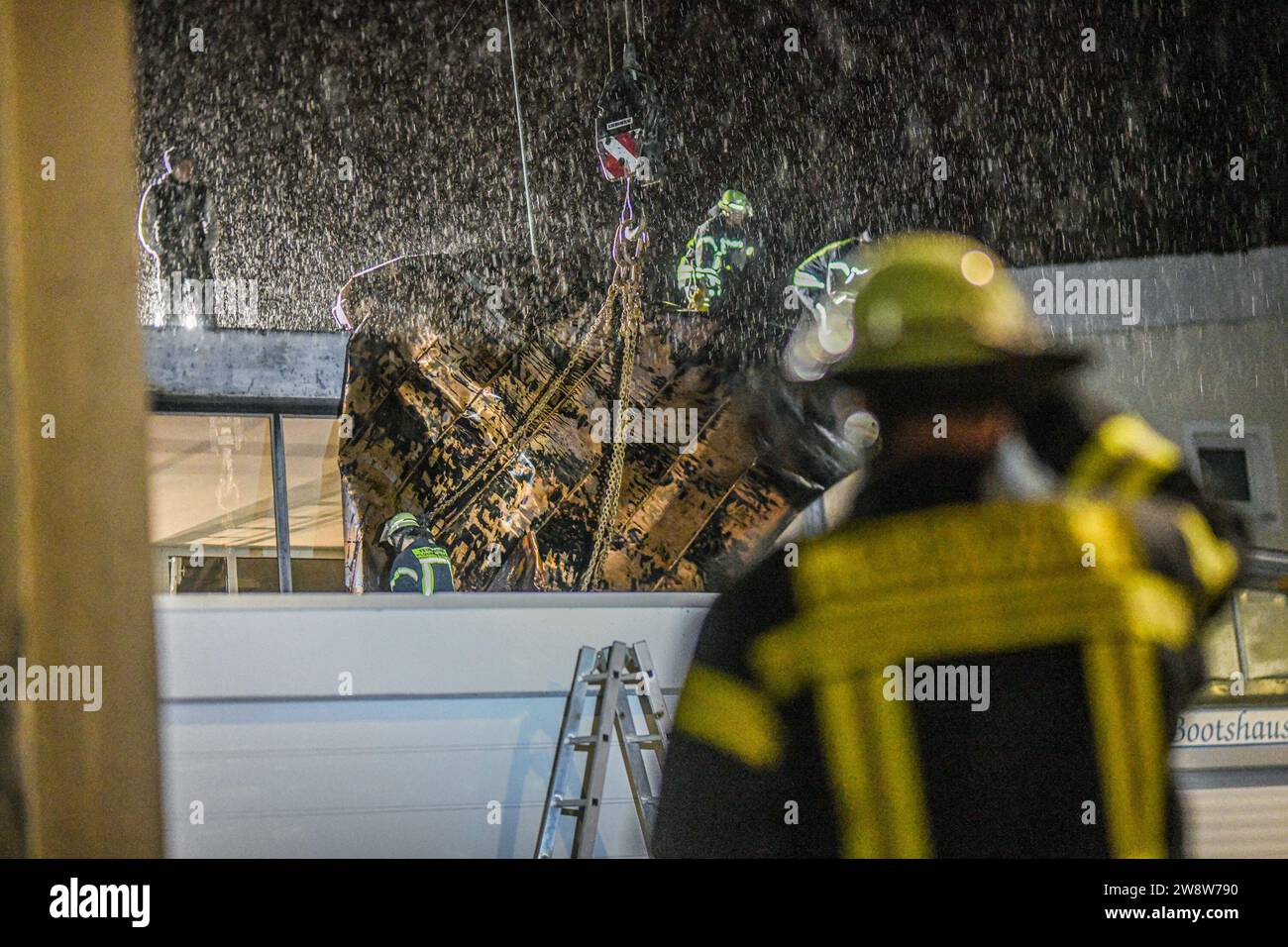 Dpatop - 22 décembre 2023, Bade-Württemberg, Plüderhausen : les pompiers sécurisent une partie du toit de leur caserne de pompiers avec une grue à la caserne de pompiers de Plüderhausen, à l'est de Stuttgart. Une tempête avec des vents de force de vent avait déjà couvert des parties du toit. Le service météorologique allemand prévoit des rafales de 90 à 110 kilomètres par heure pour les côtes de la mer du Nord et de la Baltique vendredi matin, avec des vents encore plus forts possibles. Photo : Jason Tschepljakow/dpa Banque D'Images