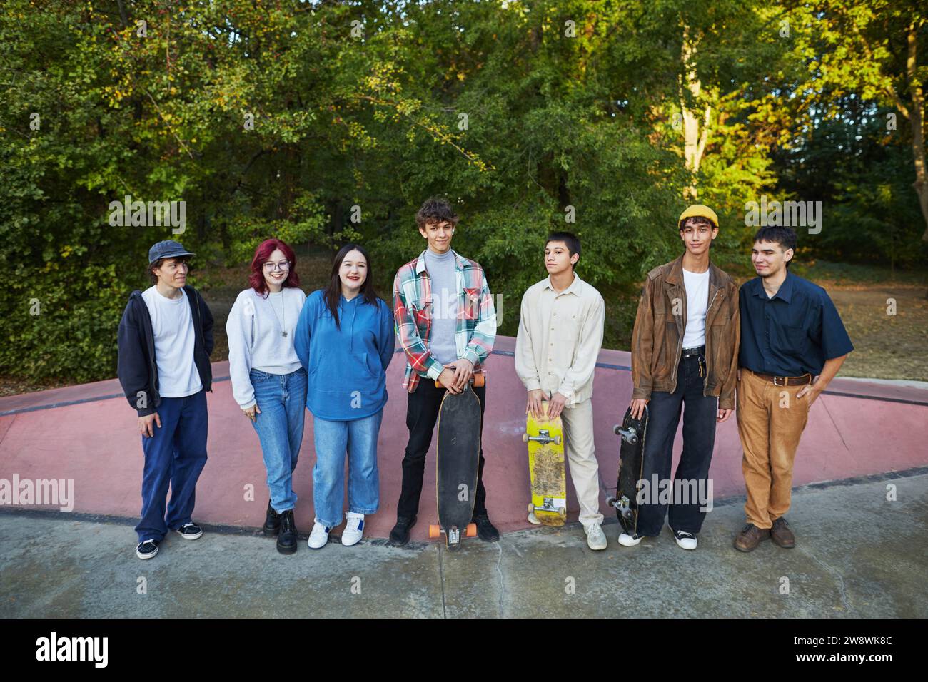 un groupe de jeunes avec des planches à roulettes se tient dans un skate park Banque D'Images