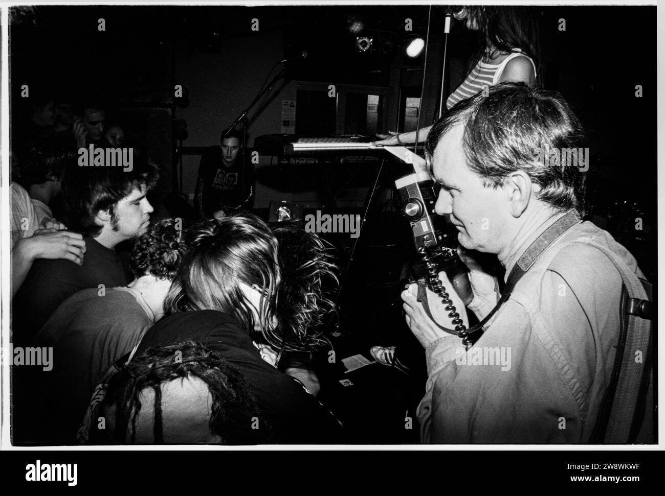 MARTIN PARR, PHOTOGRAPHE DE MAGNUM, 1994 : photographe légendaire de Magnum Martin Parr prenant une photo lors du concert commandé au groupe indépendant Salad à l'Université Glamorgan au pays de Galles, Royaume-Uni, le 8 avril 1994. Ses images résultantes ont été utilisées dans l'illustration et un mini-livre spécial qui est venu avec leur premier album 'Drink Me'. Photo : Rob Watkins. INFO SUPPLÉMENTAIRE : Martin Parr, né en 1952, est un photographe documentaire britannique renommé. Son style distinctif capture la vie quotidienne avec humour et ironie, se concentrant souvent sur des phénomènes culturels. Le travail de Parr a laissé une marque indélébile sur la photographie contemporaine. Banque D'Images