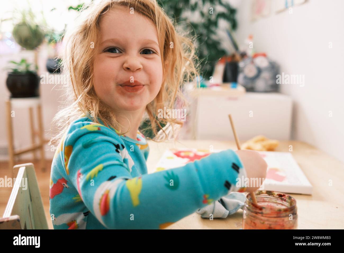 Heureux enfant peindre et sourire à la caméra Banque D'Images