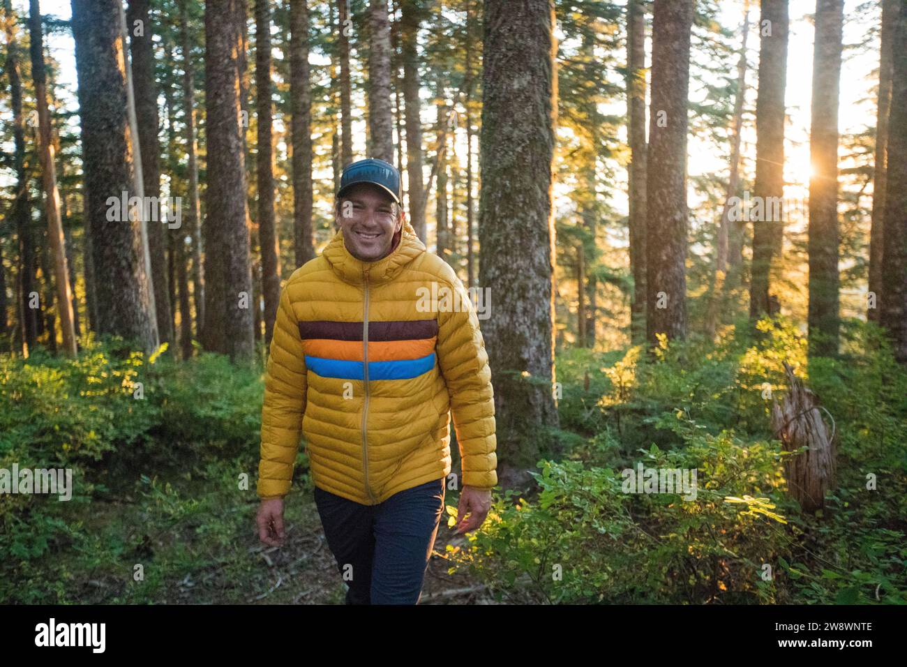 Homme randonnant à travers la forêt, portant une veste d'hiver chaude Banque D'Images