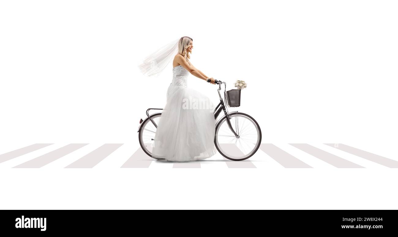 Mariée chevauchant un vélo à un passage piéton isolé sur fond blanc Banque D'Images