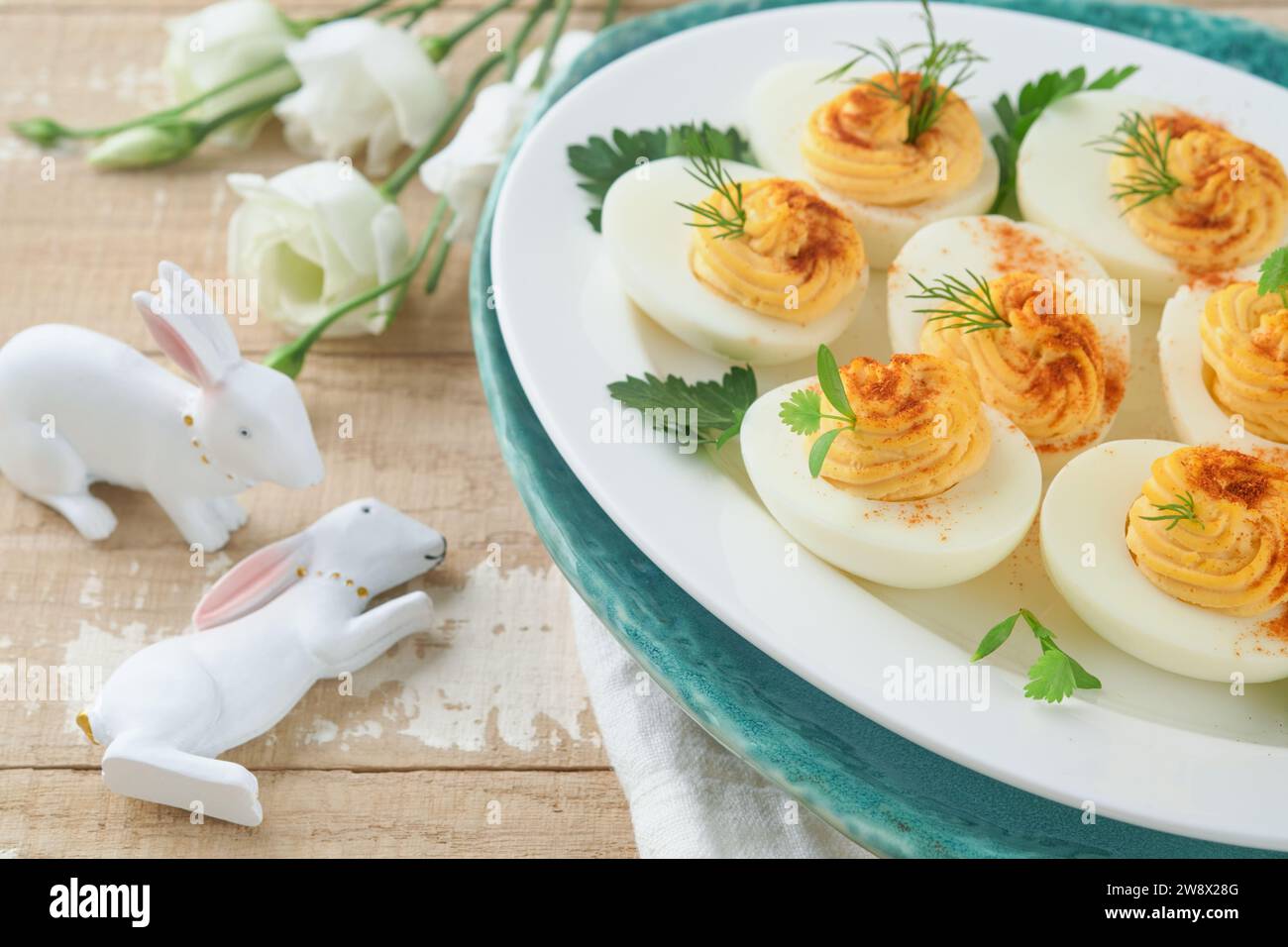 Oeufs farcis de Pâques. Brunch traditionnel de Pâques ou dîner avec œufs farcis au paprika, barres de gâteau aux carottes et gâteaux au nid au chocolat avec œufs glacés. E Banque D'Images