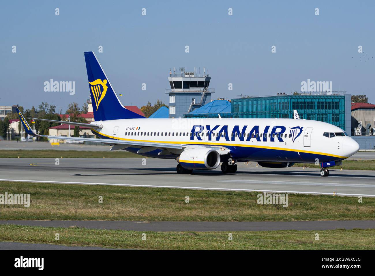 Le Boeing 737-800 Ryanair de la compagnie aérienne irlandaise low-cost décolle de l'aéroport de Lviv, avec la tour ATC en arrière-plan Banque D'Images