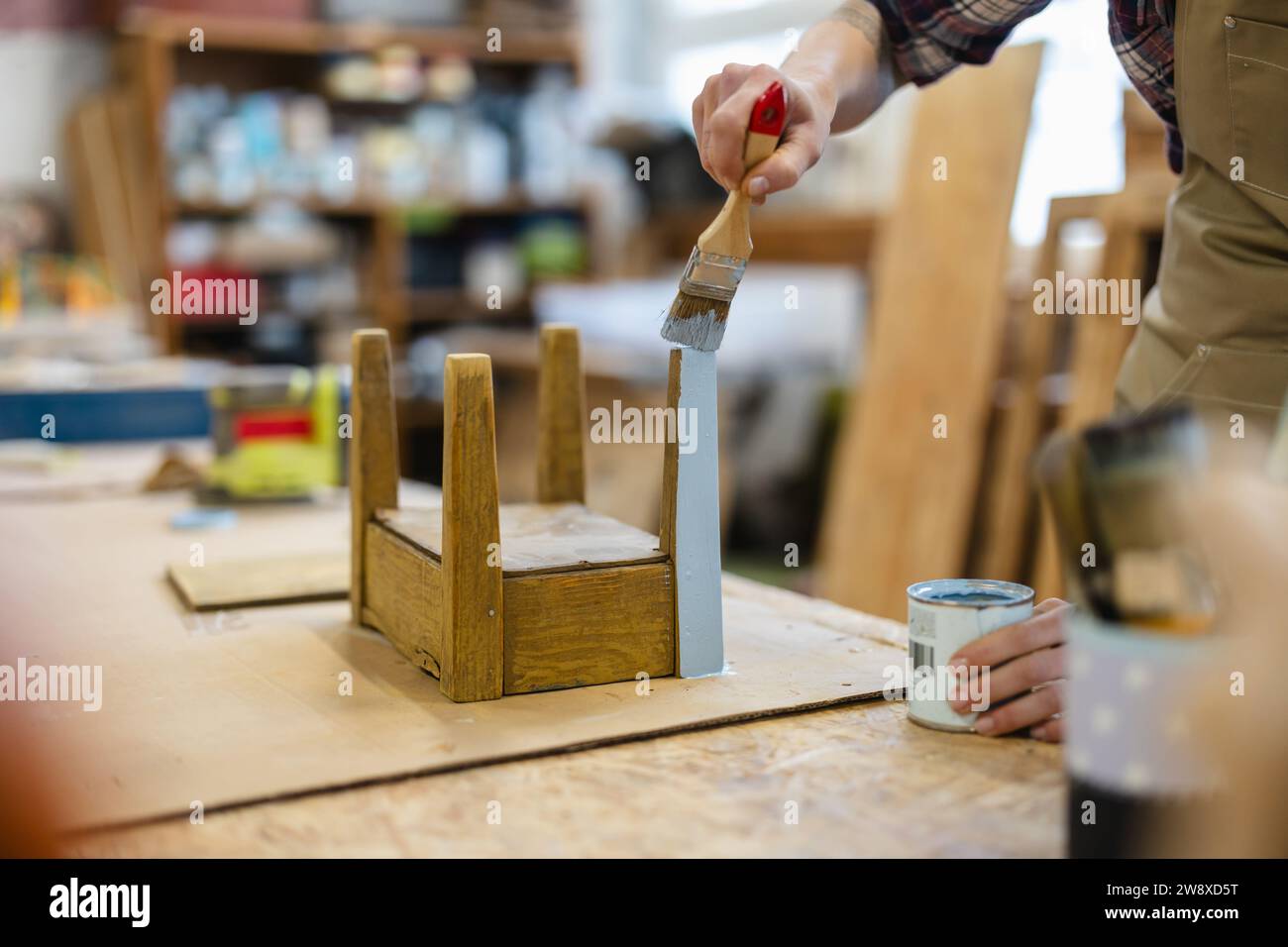 Menuisier peignant des meubles dans son atelier, gros plan Banque D'Images