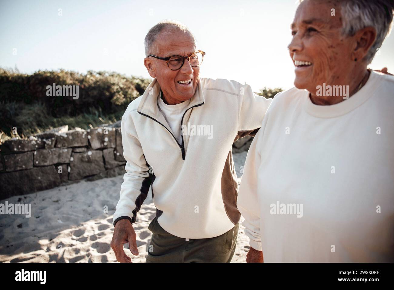 Heureux couple senior marchant ensemble à la plage Banque D'Images
