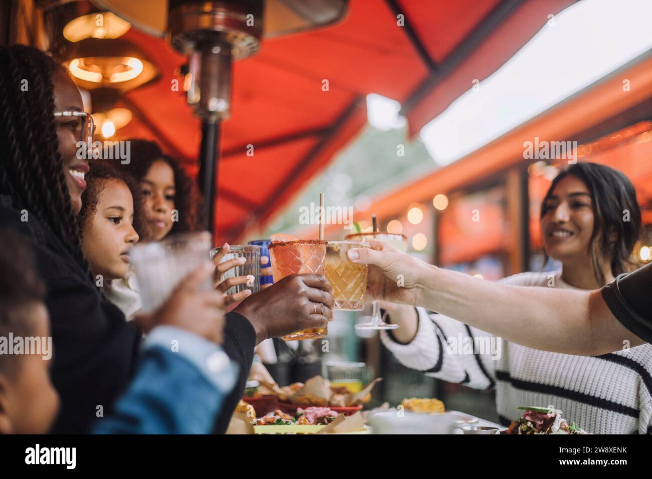 Joyeuse famille grillant des boissons pendant la célébration au restaurant Banque D'Images
