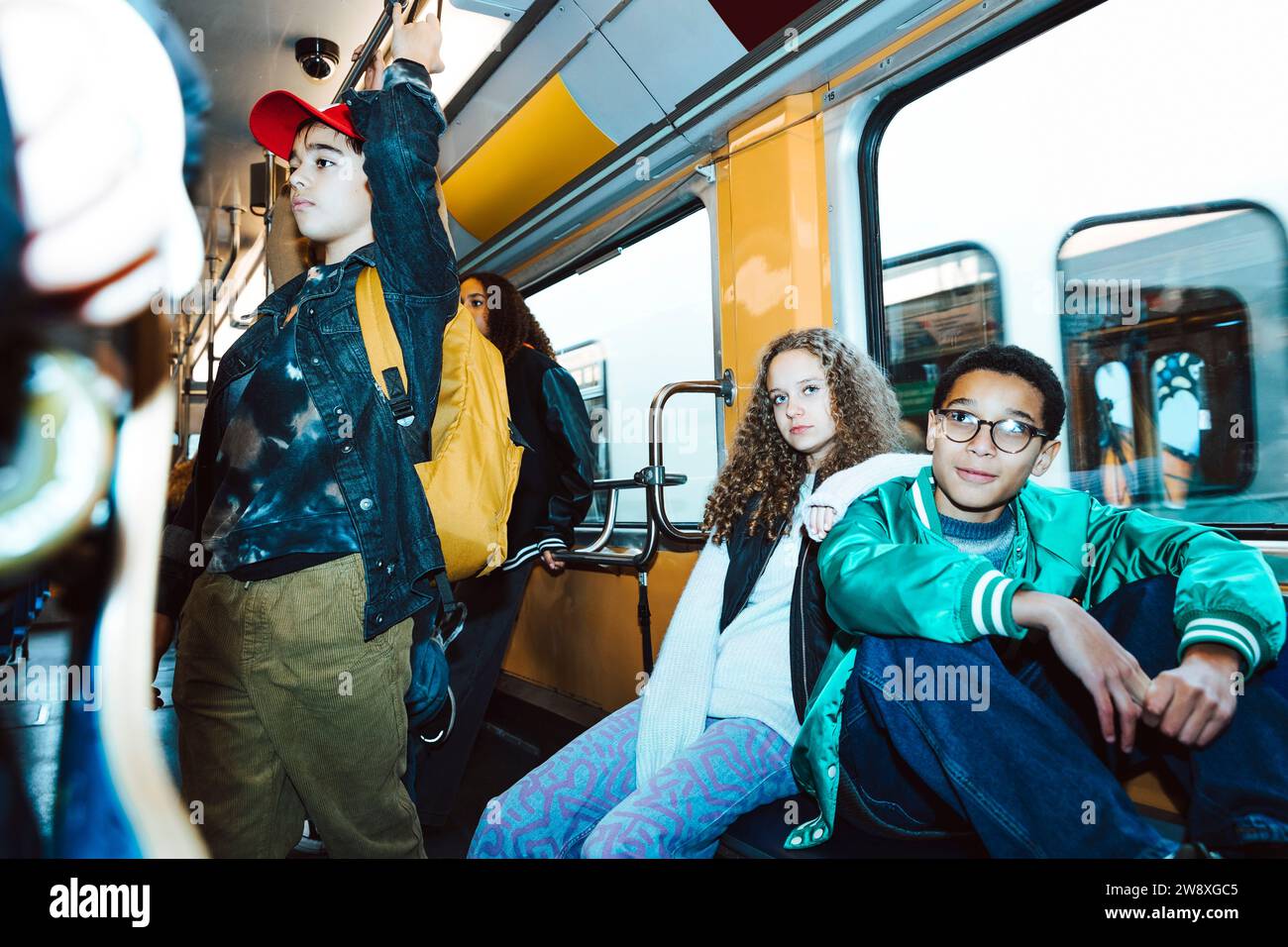 Amis masculins et féminins multiraciaux voyageant en tram pendant le week-end Banque D'Images