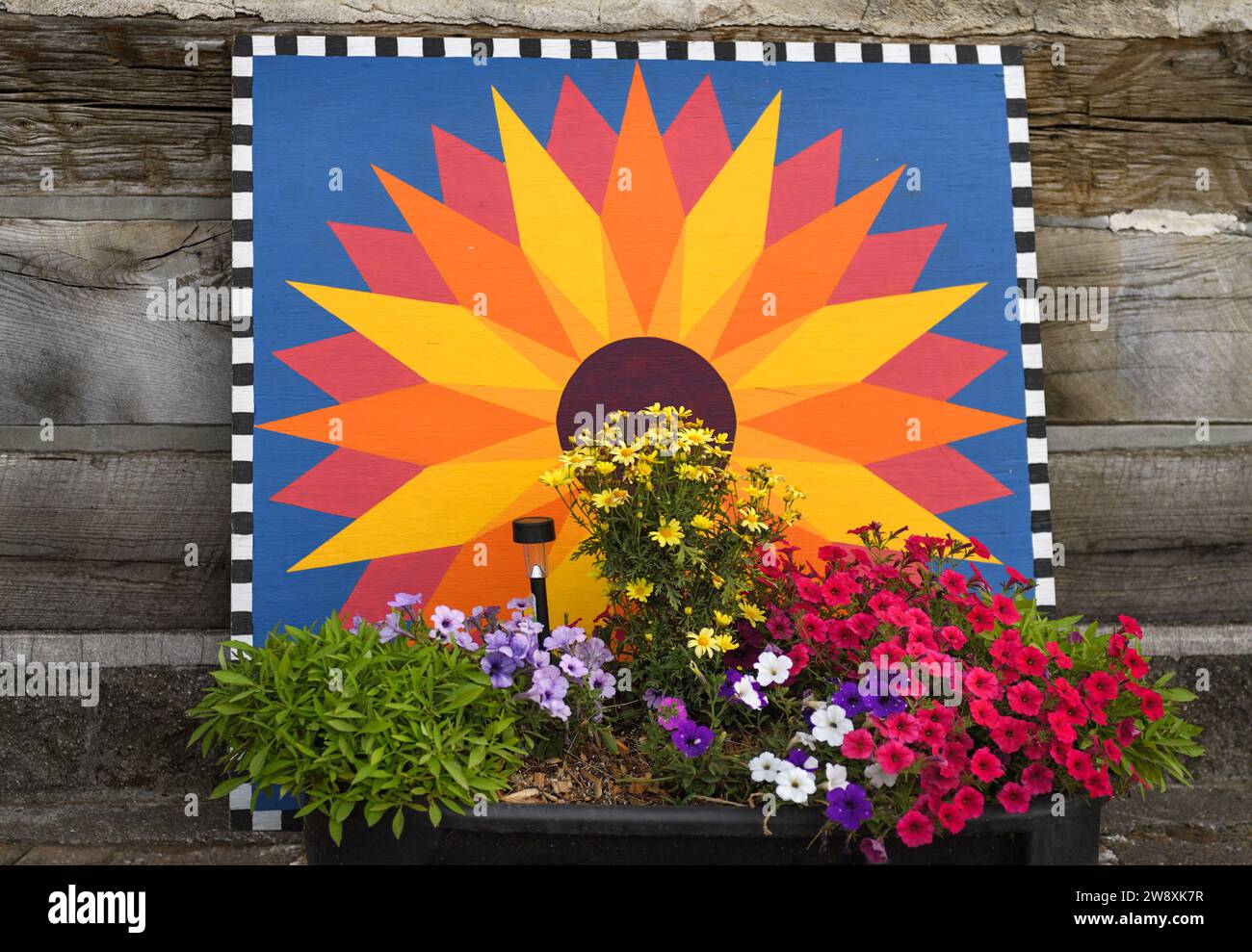 Barn Quilt and Flowers - appuyé contre la cabane en rondins Banque D'Images