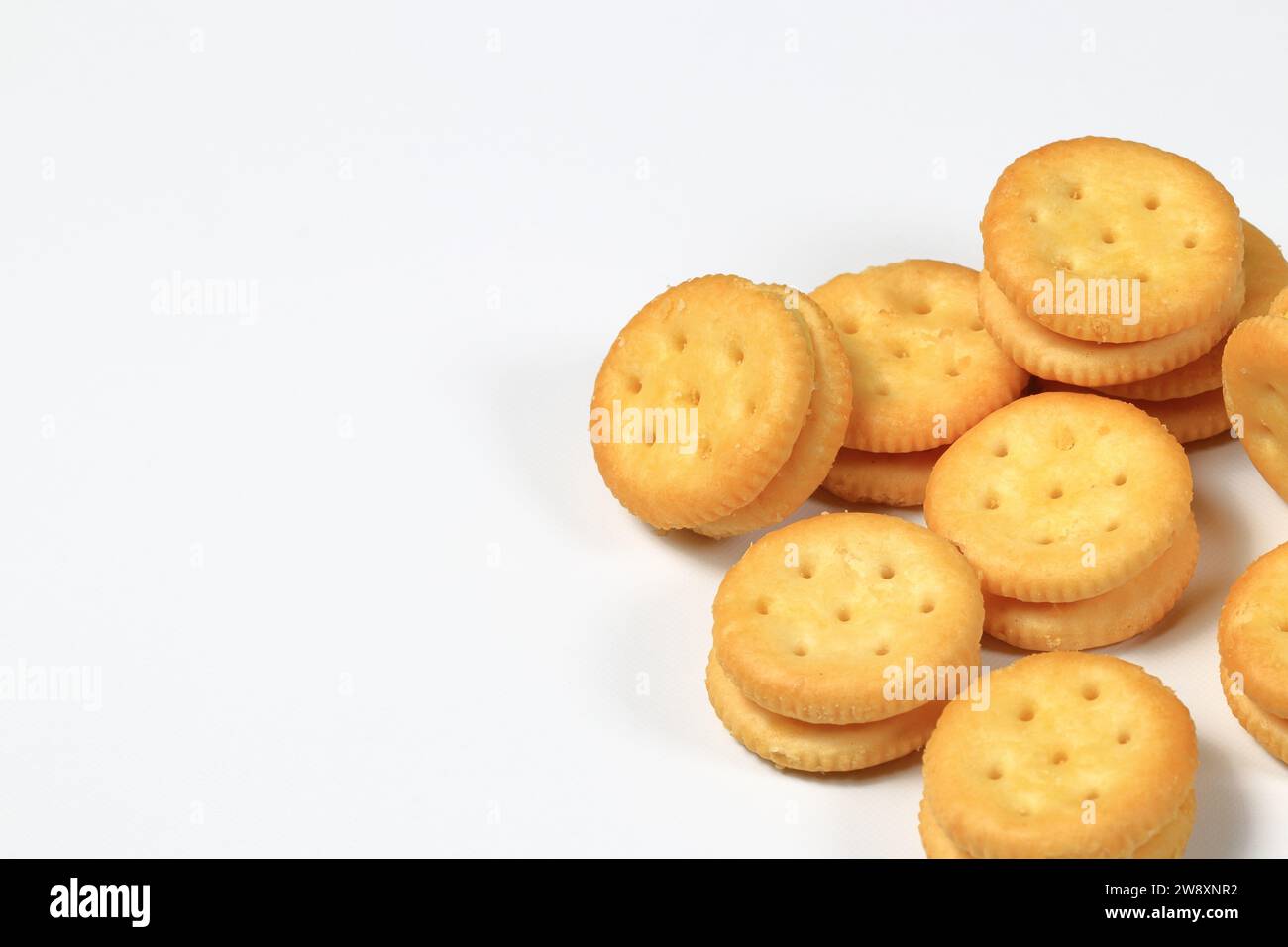 Pile de biscuits ronds prêts à l'emploi biscuits craquelins au fromage ou au fromage isolé sur fond blanc. Banque D'Images