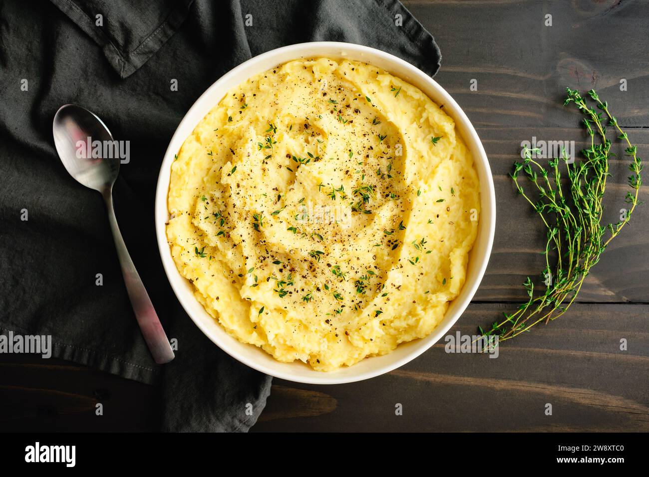 Purée de pommes de terre au mascarpone à l'ail rôti au thym frais et au poivre noir : purée de pommes de terre Yukon Gold garnie de feuilles de thym et de poivre concassé Banque D'Images
