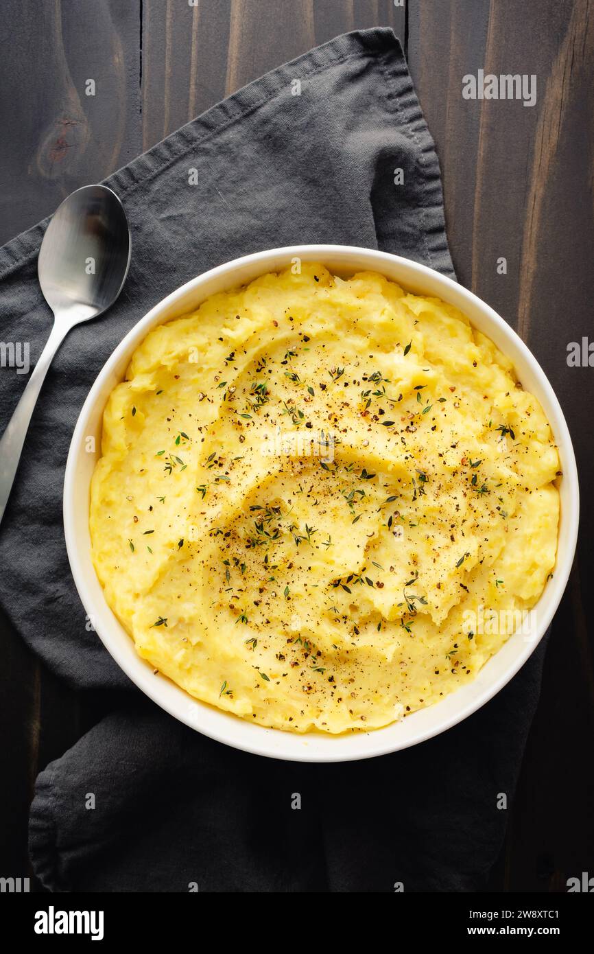 Purée de pommes de terre au mascarpone à l'ail rôti au thym frais et au poivre noir : purée de pommes de terre Yukon Gold garnie de feuilles de thym et de poivre concassé Banque D'Images