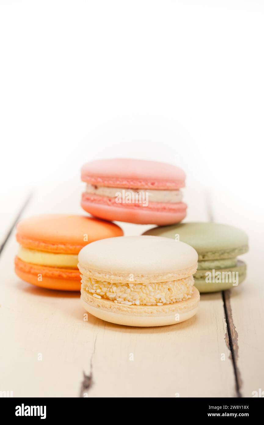Macarons français colorés sur une table en bois rustique blanc, photographie de nourriture Banque D'Images