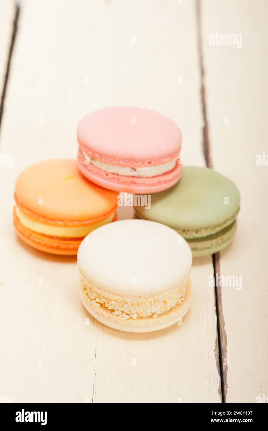 Macarons français colorés sur une table en bois rustique blanc, photographie de nourriture Banque D'Images