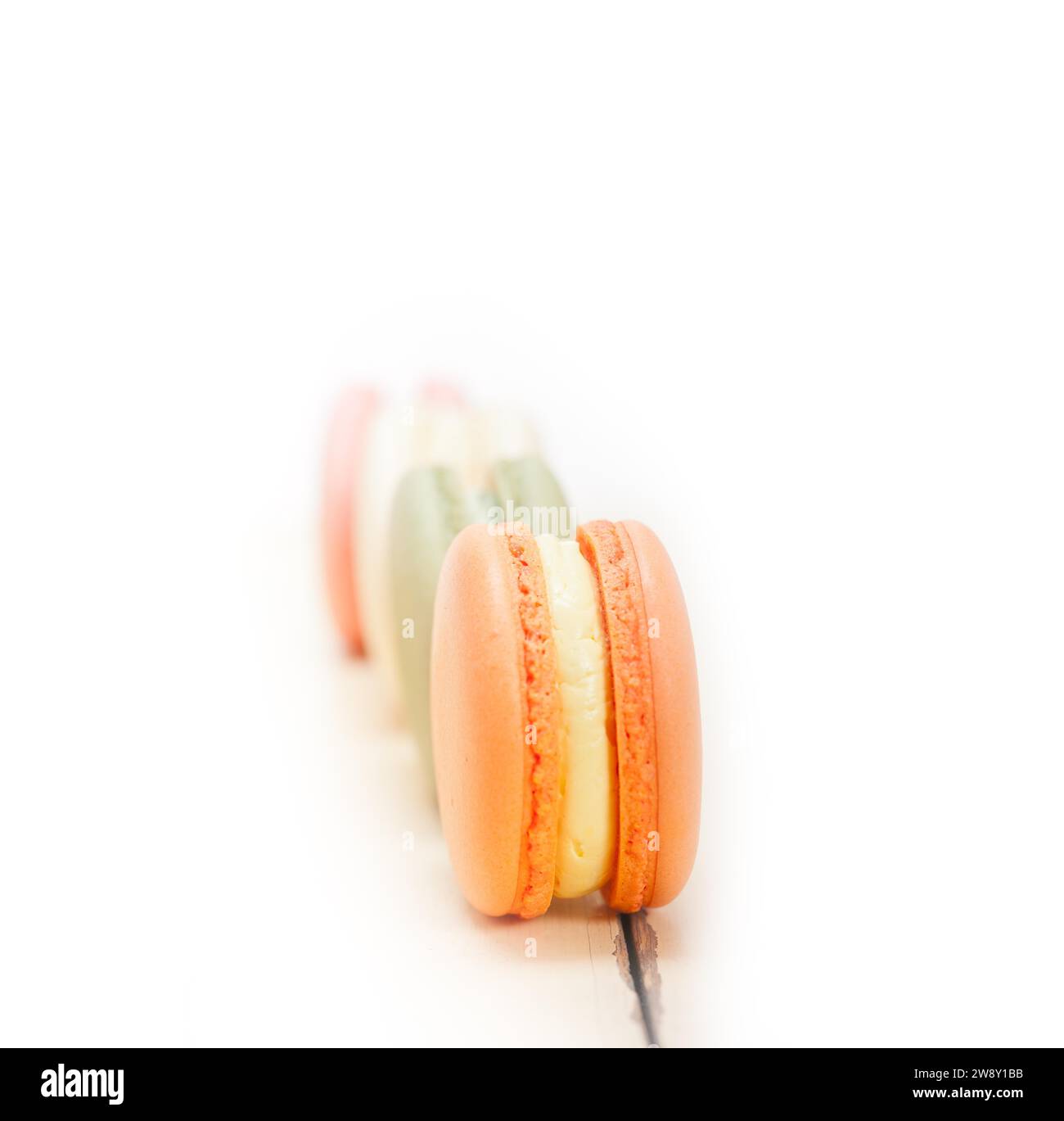 Macarons français colorés sur une table en bois rustique blanc, photographie de nourriture Banque D'Images