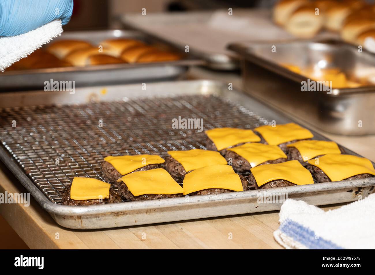 Cheeseburger sliders sont disposés sur une plaque à biscuits dans la cuisine pour cuisiner pour les invités de la fête. Banque D'Images