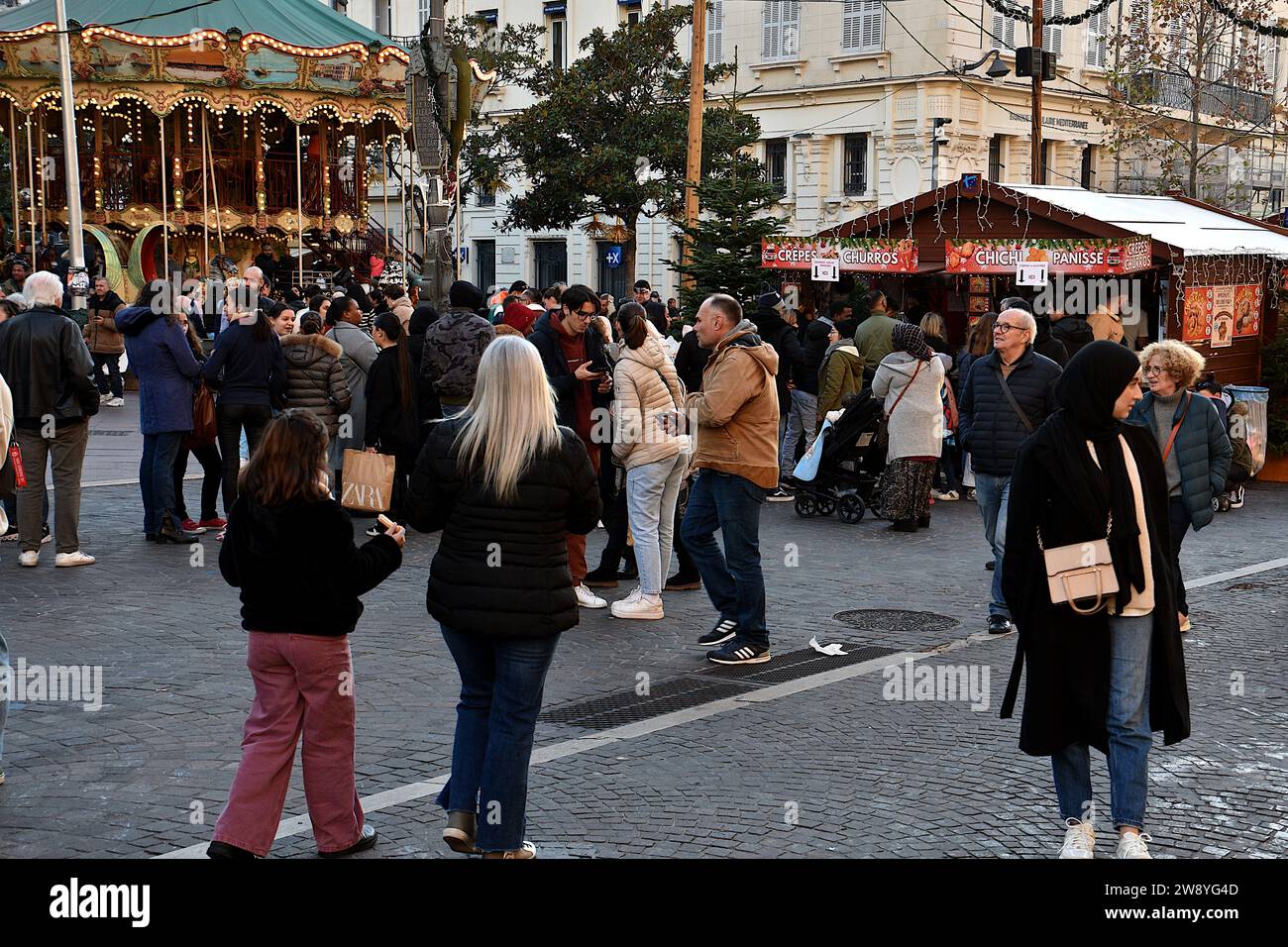 Les gens se promènent autour du marché de Noël. Au marché de Noël de Marseille, les étals des artisans et créateurs présentent bijoux, décorations, céramiques, jouets et gourmandises jusqu’au dimanche 7 janvier 2024. Banque D'Images