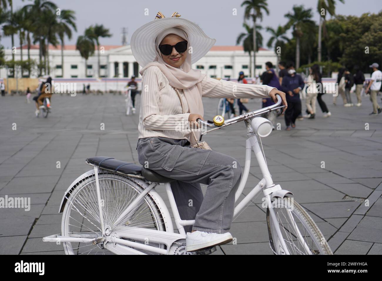 Vieille ville de Jakarta, 19 décembre 2023 - les touristes font du vélo dans la vieille ville de Jakarta avec des bâtiments historiques en arrière-plan Banque D'Images