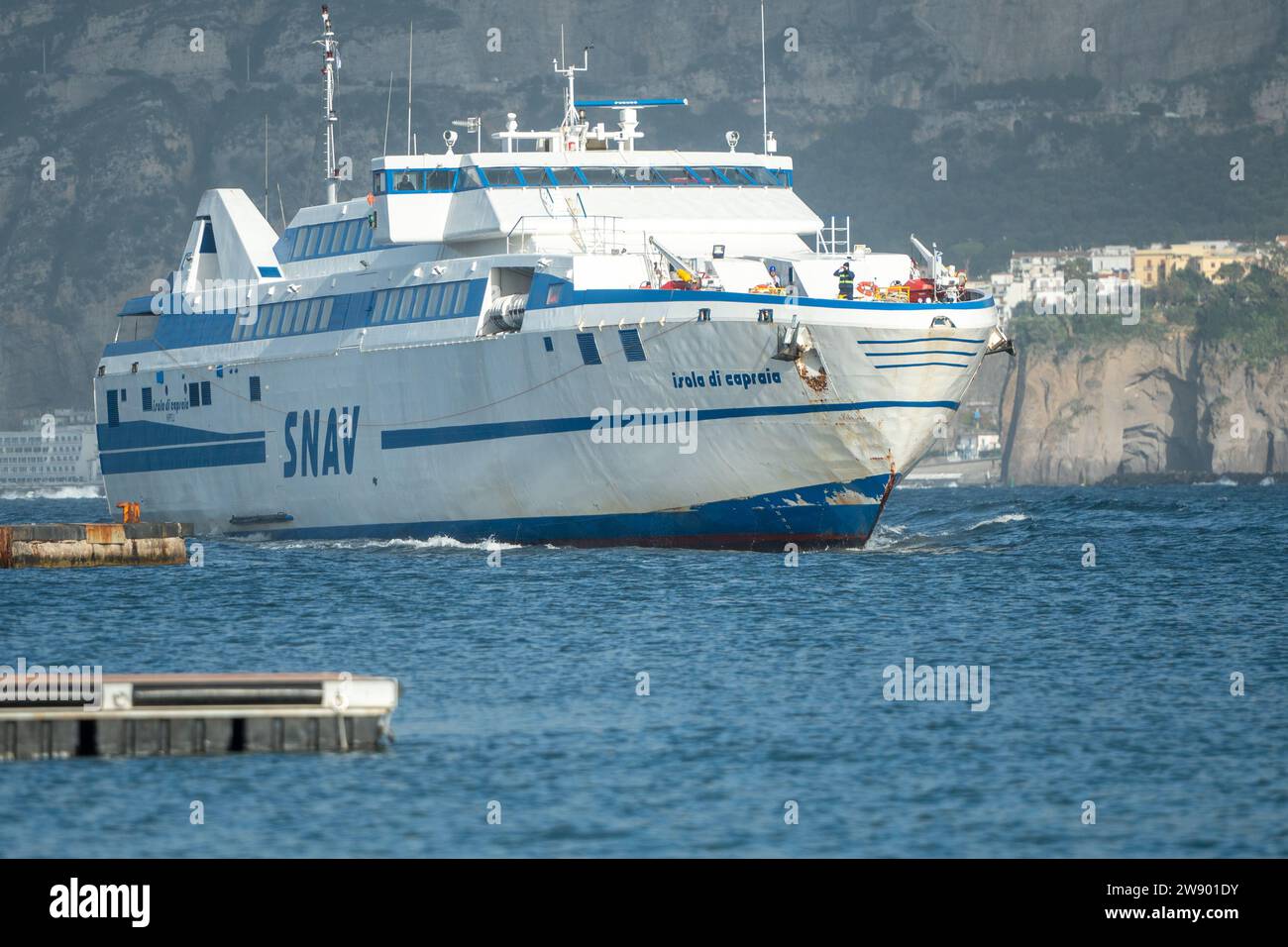 SORRENTE, ITALIE - AOÛT 2023 : Panorama du ferry rapide de la compagnie SNAV arrivant au port de Sorrente avec une puissante poussée de moteurs en W. Banque D'Images