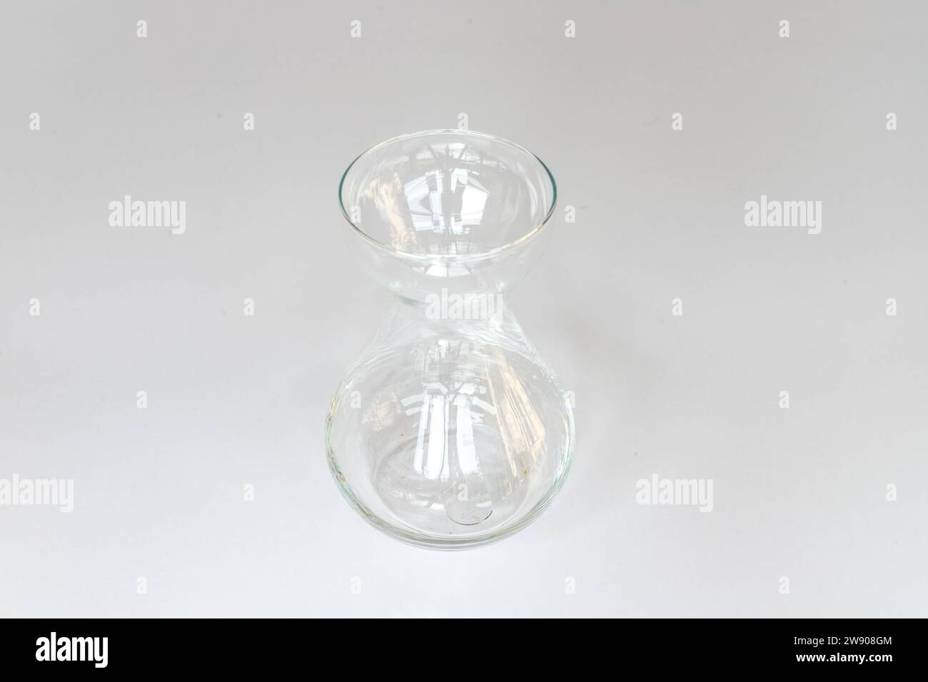 Vase en verre clair isolé sur un fond blanc. Mise au point sélective. Banque D'Images Vase en verre clair isolé sur un fond blanc. Mise au point sélective. Banque D'Images