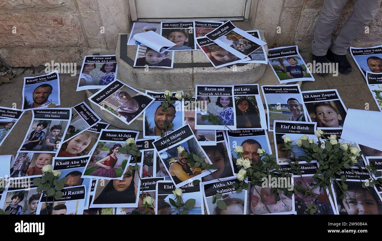 Fleurs et affiches avec des portraits de Palestiniens tués par le bombardement israélien de Gaza placées par des militants juifs israéliens pour la paix à l’entrée du consulat américain, appelant à un cessez-le-feu et pleurant les 20 000 Palestiniens tués par le bombardement israélien de la bande de Gaza le 22 décembre 2023 à Jérusalem, en Israël Banque D'Images