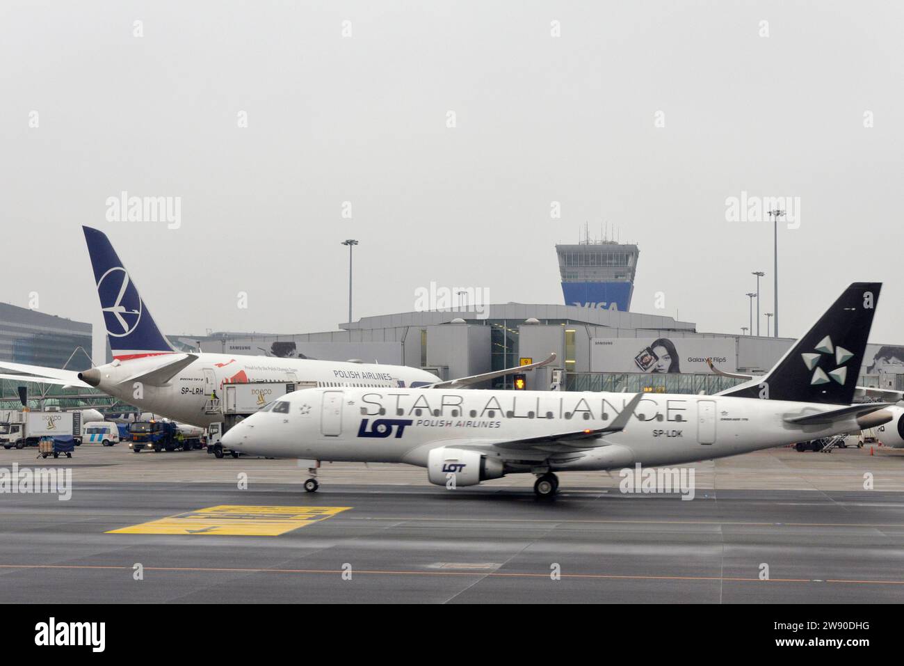 Embraer 170/175 - MSN 74 exploité par Star Alliance à l'aire de trafic de l'aéroport de Varsovie ou sur le tarmac vue générale des avions de la compagnie aérienne polonaise LOT par temps nuageux Banque D'Images