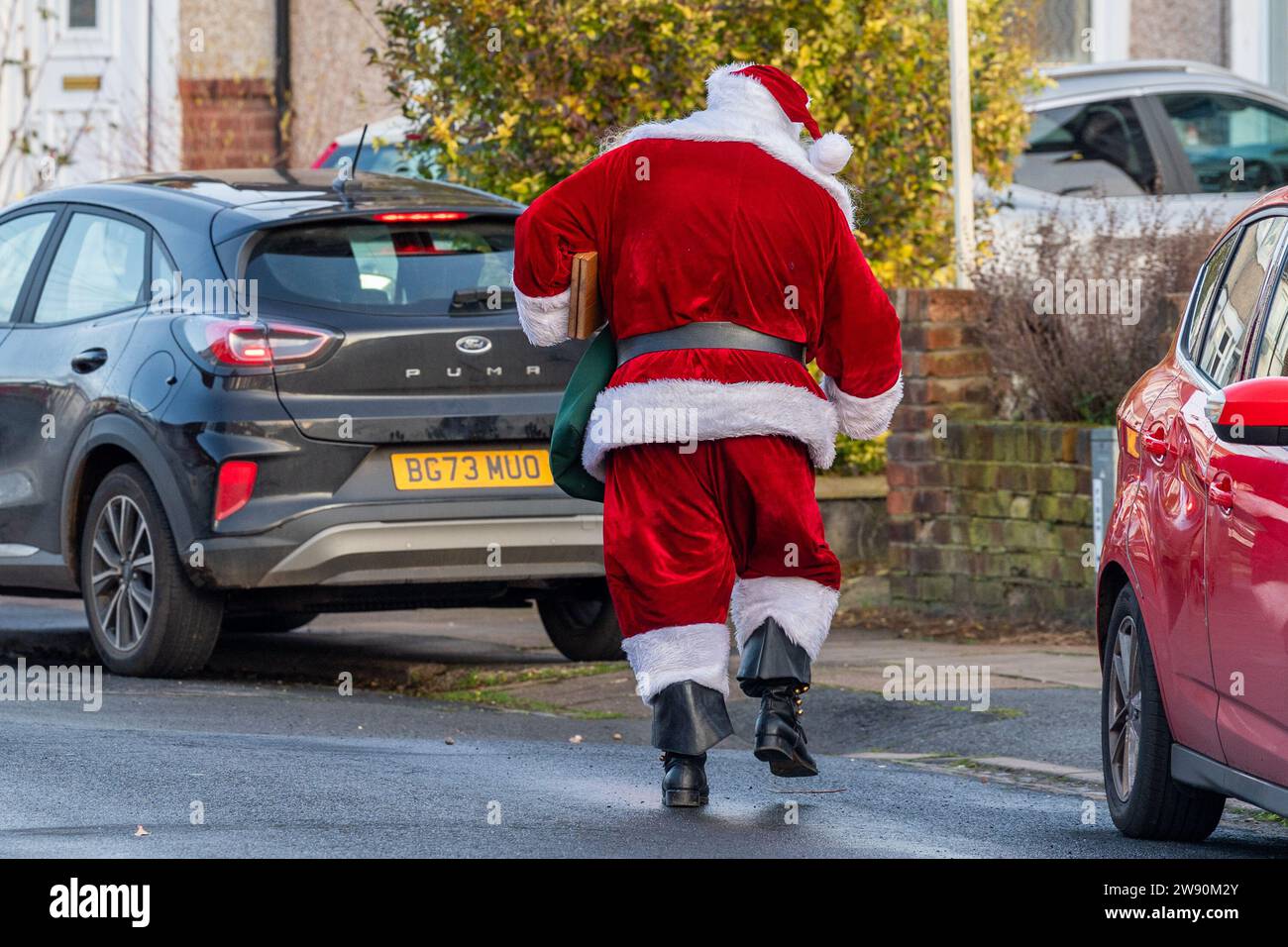 Radford, Coventry, Royaume-Uni. 23 décembre 2023. Le Père Noël a été vu rendre visite à des enfants dans un lotissement à Radford ce matin dans ce qui était une visite impromptue. Le Père Noël dansait dans la rue après avoir rendu visite à des enfants. Crédit : AG News/Alamy Live News Banque D'Images