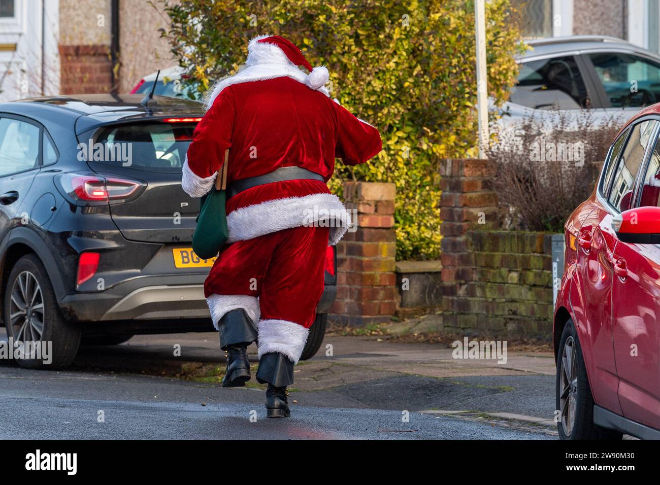 Radford, Coventry, Royaume-Uni. 23 décembre 2023. Le Père Noël a été vu rendre visite à des enfants dans un lotissement à Radford ce matin dans ce qui était une visite impromptue. Le Père Noël dansait dans la rue après avoir rendu visite à des enfants. Crédit : AG News/Alamy Live News Banque D'Images