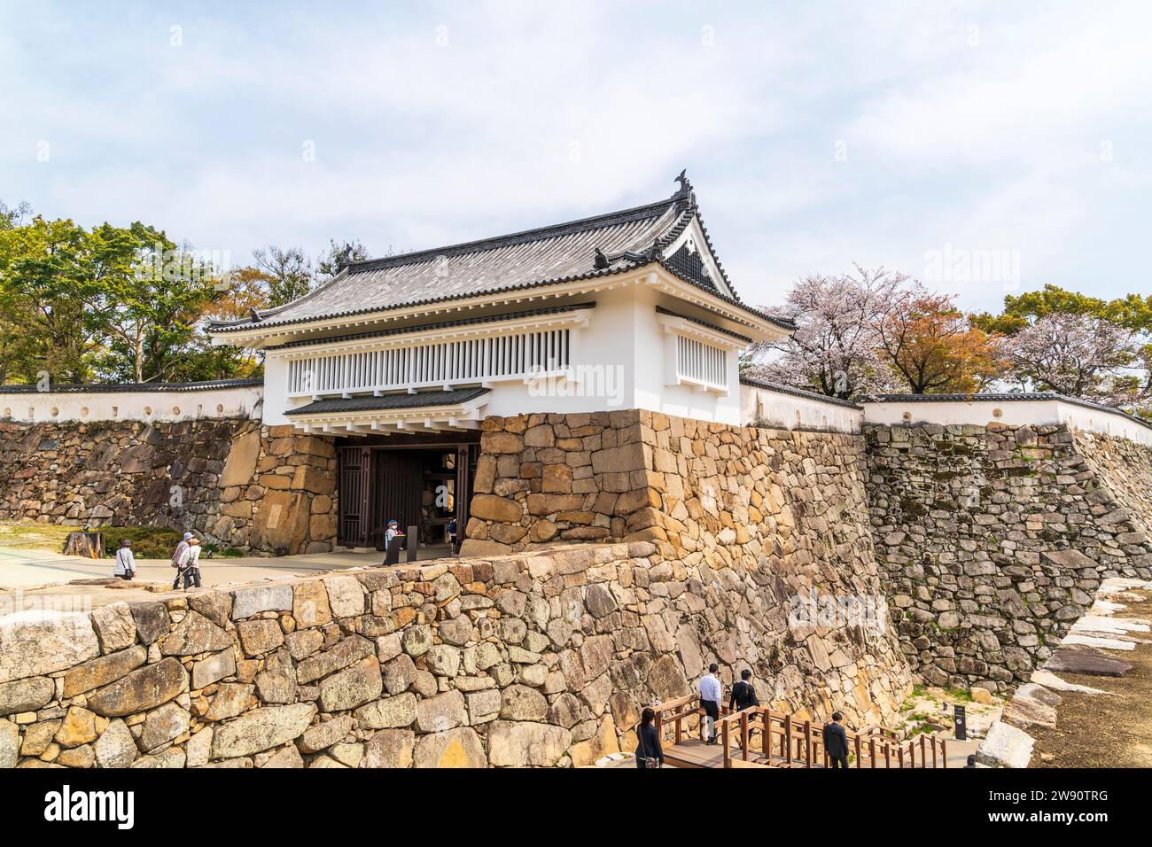 Murs en pierre Ishigaki surmontés de murs en plâtre dobei blanc et la porte Akazunomon au château de Fukuyama. Une porte yaguramon, style watariyagura. Ciel bleu. Banque D'Images