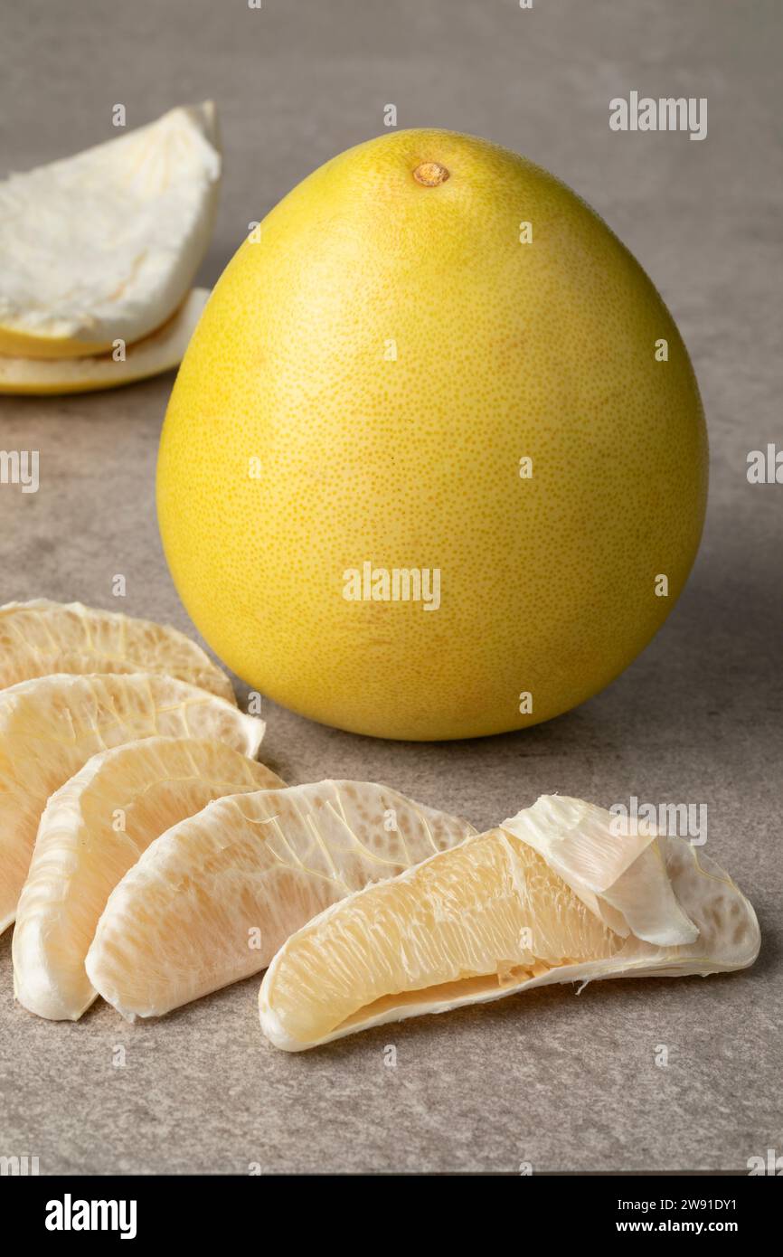 Pomelo jaune frais entier et tranches de pomelo pelées se rapprochent Banque D'Images