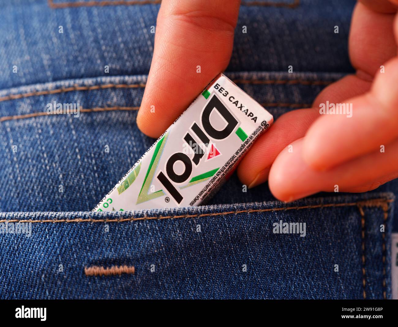 Tambov, Fédération de Russie - 20 décembre 2023 Une femme sort un paquet de chewing-gum Dirol dans une poche arrière de jeans. Banque D'Images